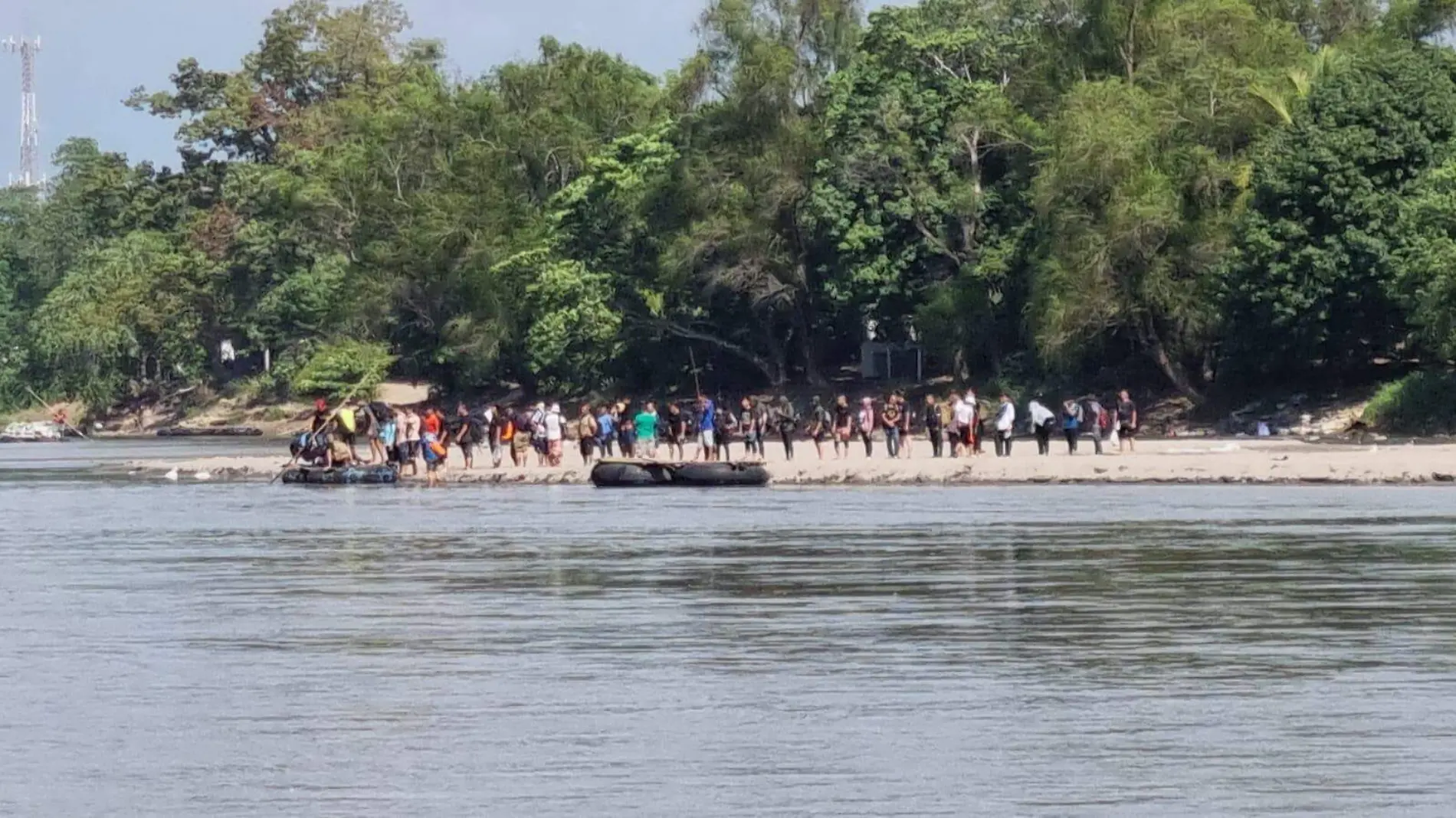 Migrantes esperando cruzar el río Suchiate